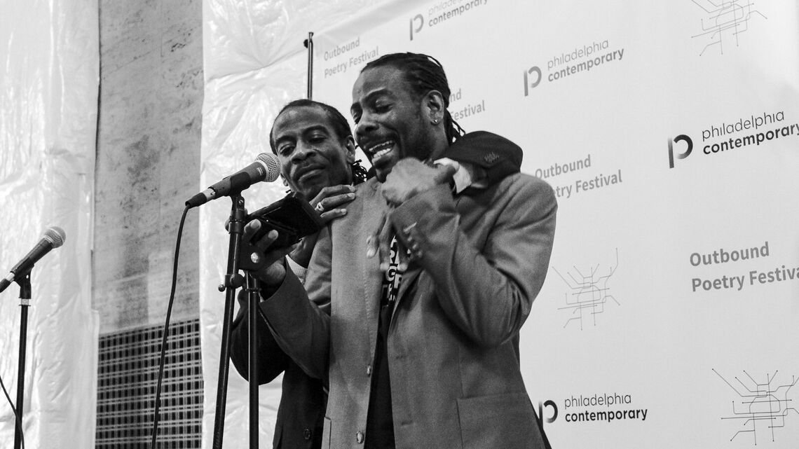 Two men standing at a mic