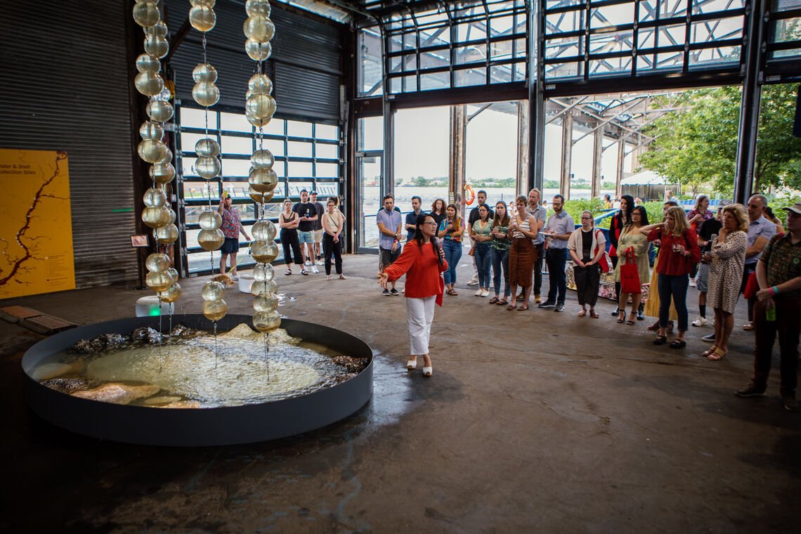 Artist Jean Shin standing beside the living laboratory and fountain